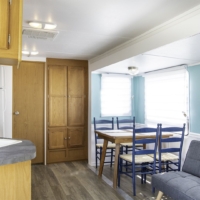 Cuisine en bois clair et salle à manger avec grandes fenêtres – roulotte Four Winds 437