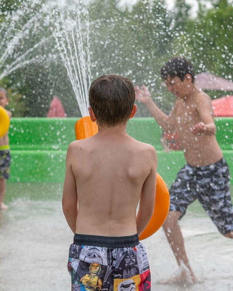 Jeune garçon dans l’espace jeux d’eau du Camping Magog Orford