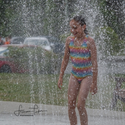 Fille courant dans les jets d’eau Fille qui court dans les jeux d'eau pour enfants en Estrie