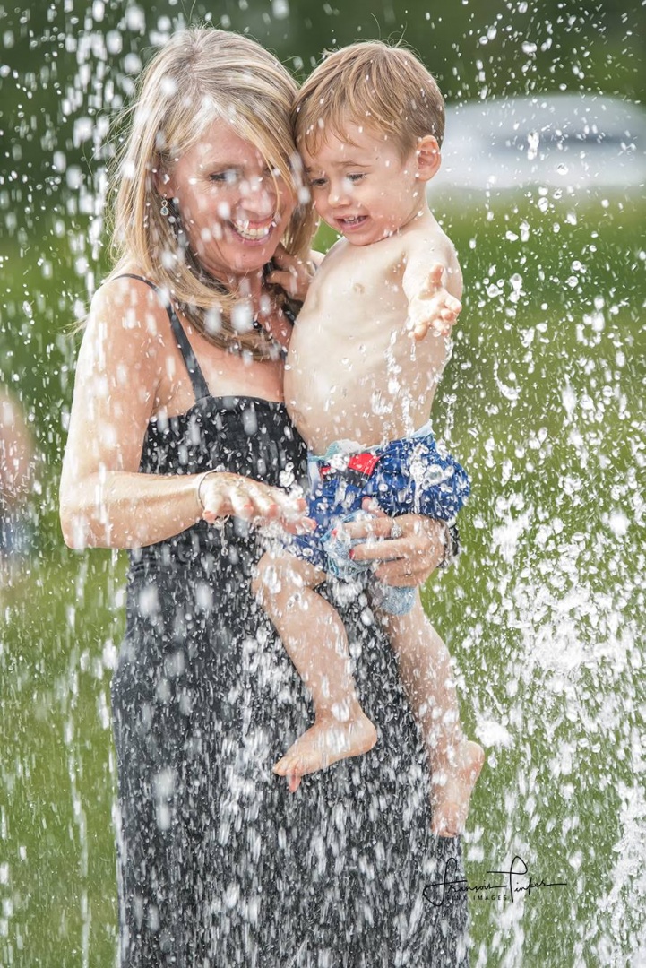 Maman et enfant sous les jets d'eau au camping en Estrie
