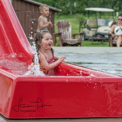 Glissade d’eau pour enfants au Camping Magog Orford Enfant qui s’amuse sur une glissade d’eau rouge au Camping Magog Orford