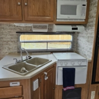 Cuisine équipée avec micro-ondes, four, évier et rangements – Roulotte De Parc 435